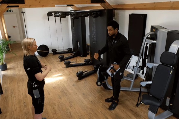 EMS studio with trainer and client preparing for session