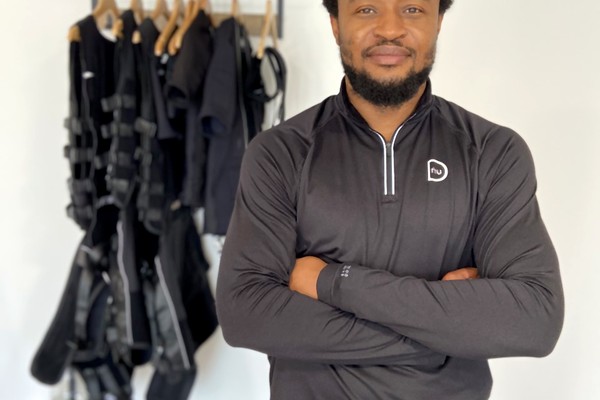 EMS trainer standing with arms crossed inside studio